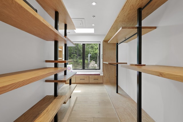 interior space with a skylight and light hardwood / wood-style flooring