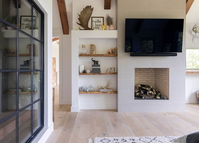 interior space with beam ceiling and light hardwood / wood-style floors