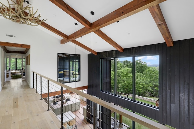 hallway featuring vaulted ceiling with beams, an inviting chandelier, light hardwood / wood-style flooring, and plenty of natural light