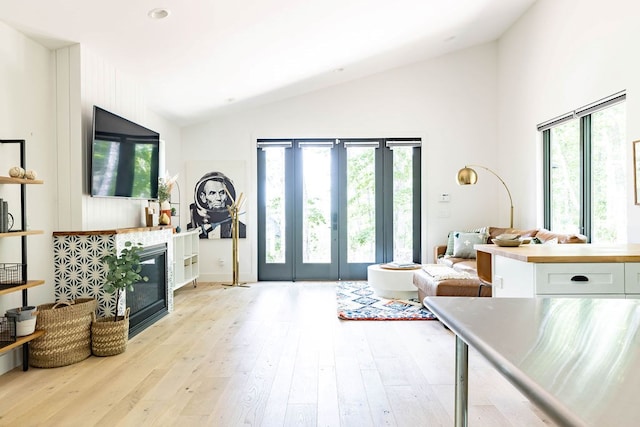 interior space with light hardwood / wood-style flooring and lofted ceiling