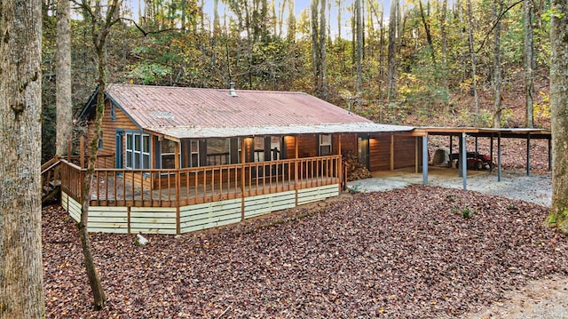 rear view of property featuring a deck and a carport