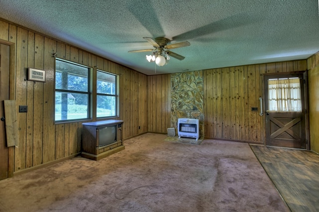 unfurnished room featuring ceiling fan, a textured ceiling, carpet flooring, and heating unit