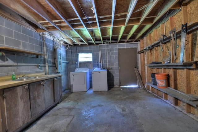 below grade area featuring separate washer and dryer, a sink, and concrete block wall