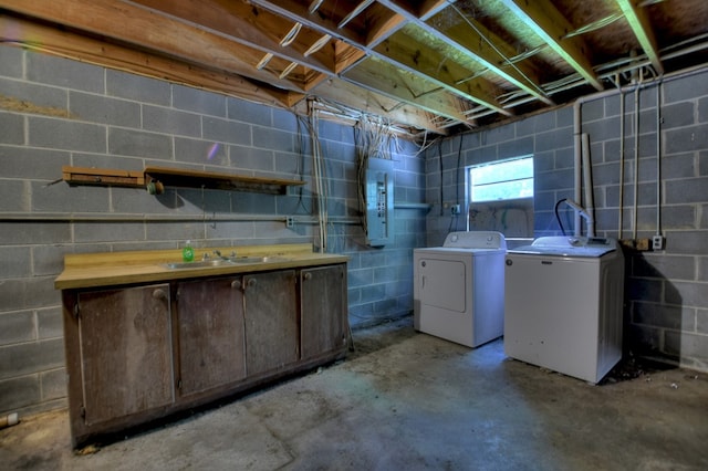 basement with refrigerator, concrete block wall, a sink, and independent washer and dryer