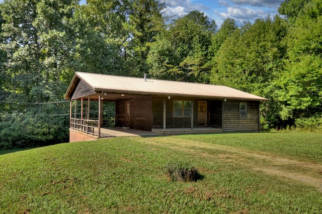 view of front of property with metal roof and a front lawn