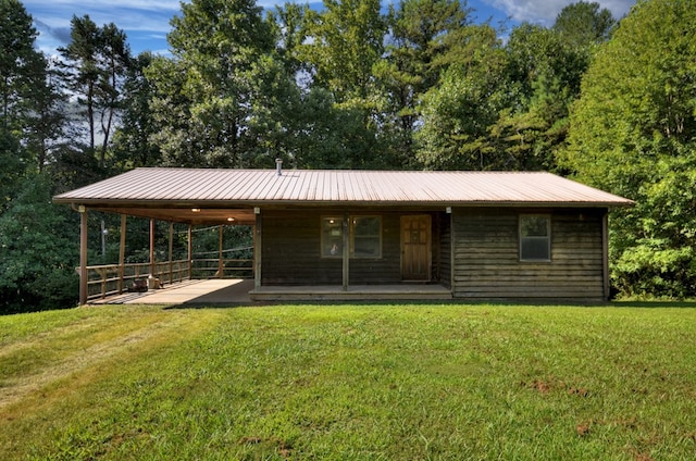 rear view of property featuring metal roof, a yard, and a porch