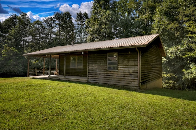 exterior space featuring metal roof and a yard