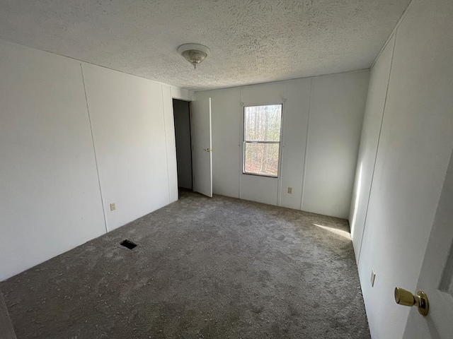 empty room featuring carpet floors and a textured ceiling