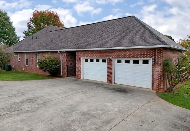 view of side of home with central AC and a garage