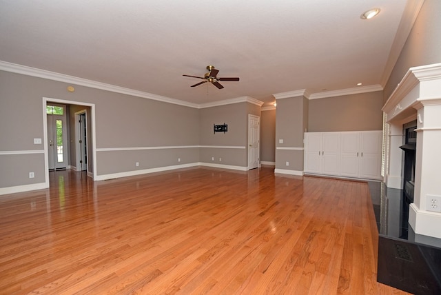 unfurnished living room with light hardwood / wood-style flooring, ceiling fan, crown molding, and a tiled fireplace