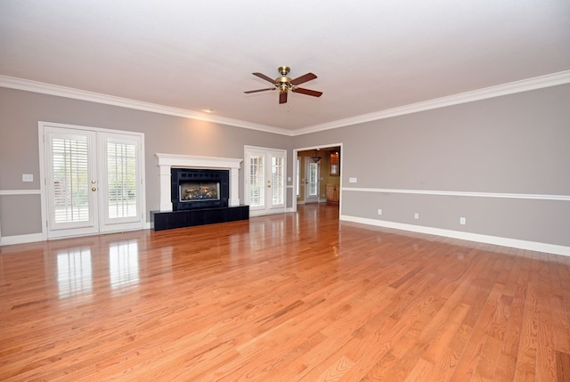 unfurnished living room with a tile fireplace, french doors, ceiling fan, and ornamental molding