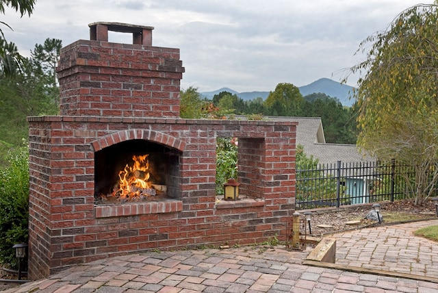 view of patio / terrace with a mountain view and an outdoor brick fireplace