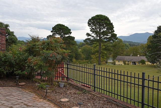 view of gate featuring a mountain view and a yard