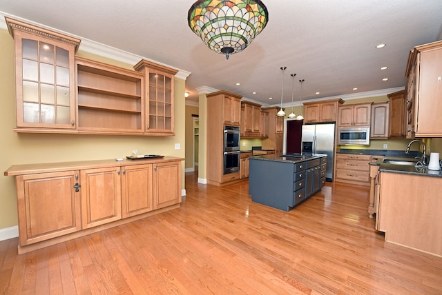 kitchen featuring sink, stainless steel appliances, decorative light fixtures, a kitchen island, and ornamental molding