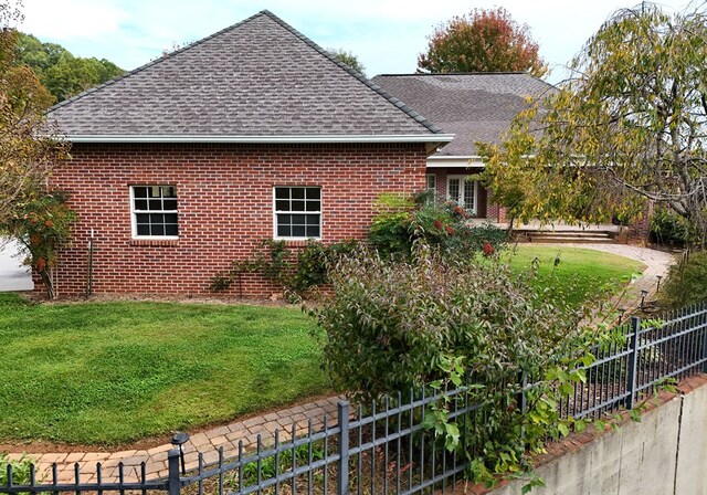 1507 Cedar View Ln, Hiawassee, GA 30546 - view of property exterior featuring brick siding, roof with shingles, and fence private yard
