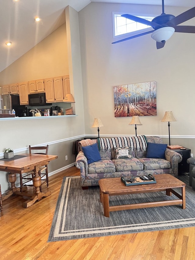 living area featuring high vaulted ceiling, light wood-style flooring, and ceiling fan