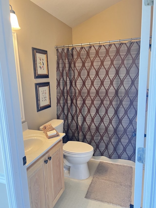 bathroom featuring curtained shower, toilet, vaulted ceiling, tile patterned floors, and vanity