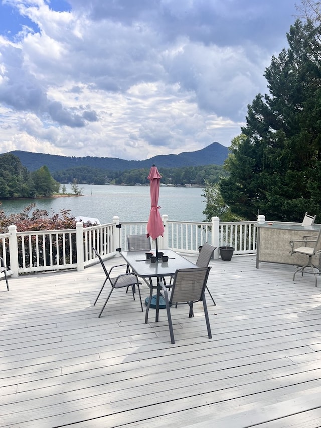 wooden deck with a water and mountain view