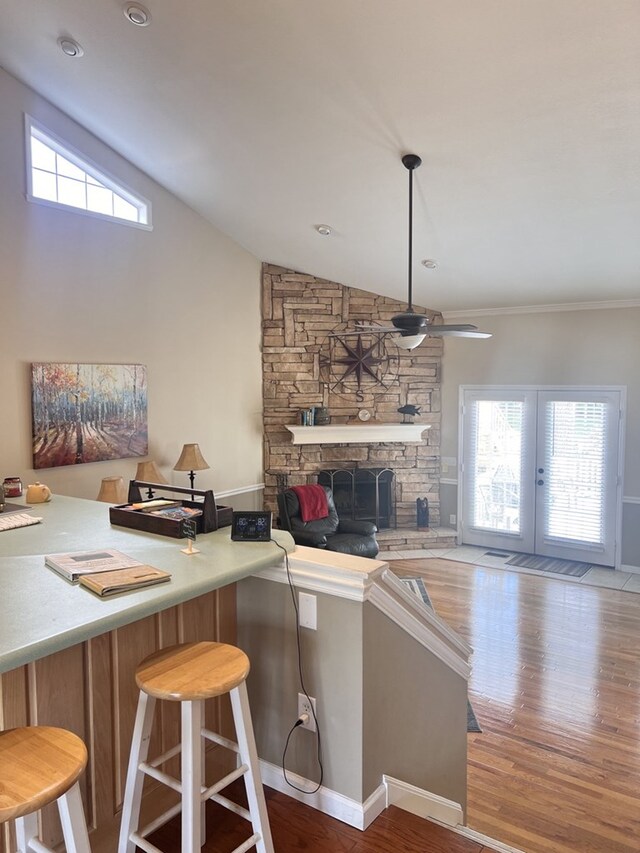 kitchen featuring a fireplace, vaulted ceiling, hardwood / wood-style floors, and ceiling fan