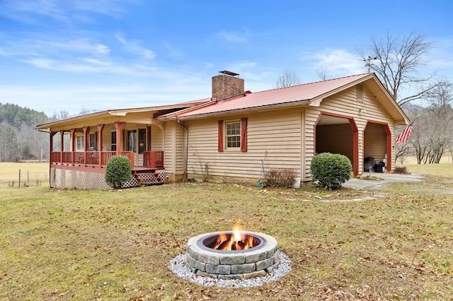 exterior space with a porch, a front lawn, and a fire pit