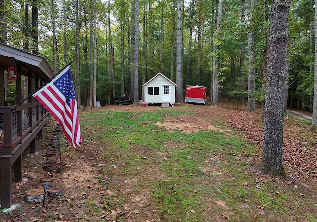 view of yard with an outdoor structure and a forest view