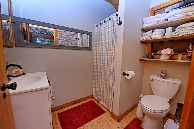full bath featuring toilet, a shower with curtain, wood finished floors, vanity, and baseboards