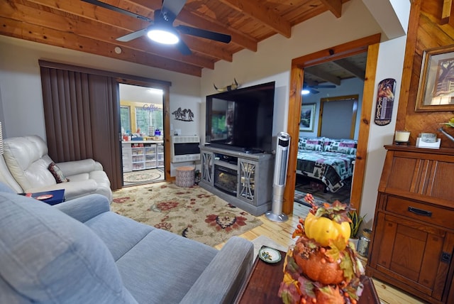living room featuring ceiling fan, wood ceiling, beamed ceiling, a fireplace, and light wood-type flooring