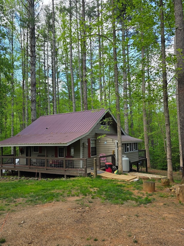 rear view of house featuring metal roof and a deck