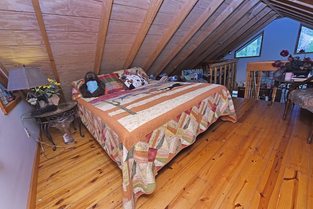 bedroom with vaulted ceiling, hardwood / wood-style flooring, and wooden ceiling