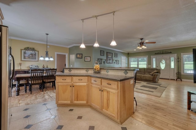 kitchen featuring hanging light fixtures, light brown cabinets, stainless steel refrigerator, and a kitchen island