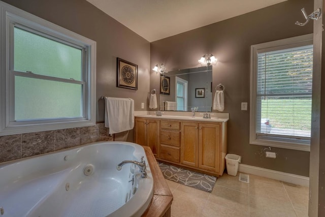 bathroom with tile patterned flooring, vanity, and a bath