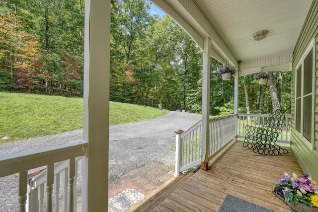 wooden terrace with covered porch and a lawn