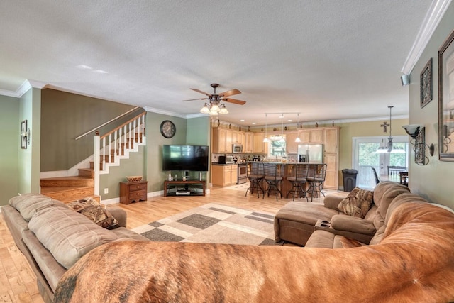 living room featuring crown molding, a textured ceiling, and light wood-type flooring