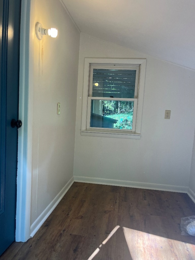 unfurnished room featuring vaulted ceiling and dark hardwood / wood-style flooring