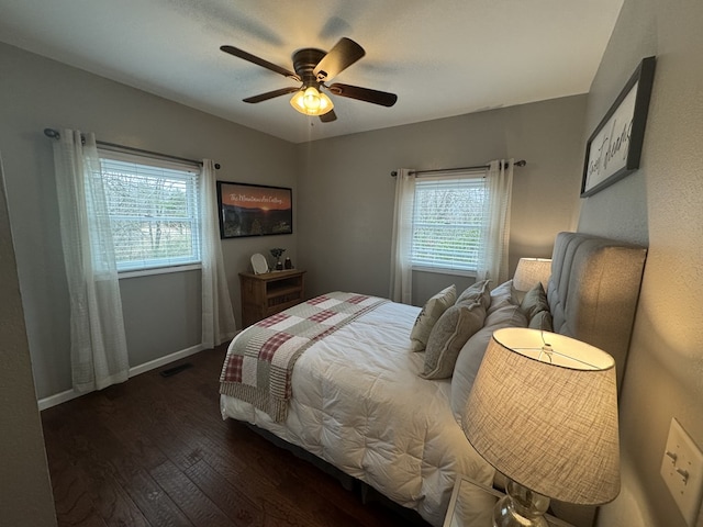 bedroom with dark wood-type flooring, ceiling fan, and multiple windows