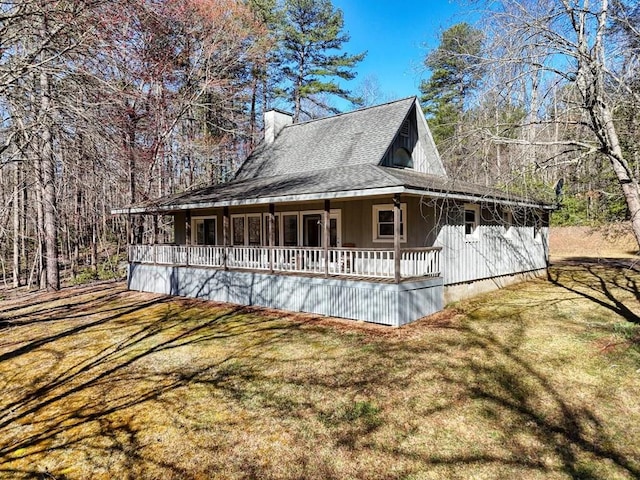view of front of property with a porch, a front lawn, and a shingled roof
