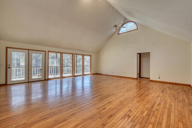 unfurnished living room featuring baseboards, high vaulted ceiling, light wood-style flooring, and a ceiling fan