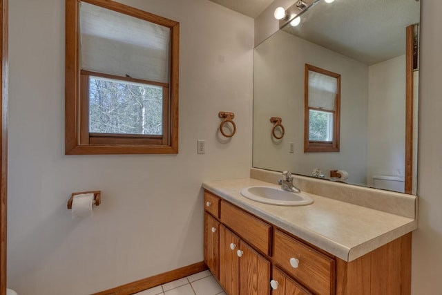 bathroom featuring vanity, tile patterned floors, toilet, and a healthy amount of sunlight