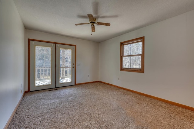 empty room with visible vents, baseboards, ceiling fan, a textured ceiling, and light colored carpet