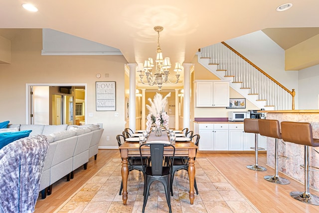 dining area with recessed lighting, a chandelier, stairs, light wood-style flooring, and ornate columns