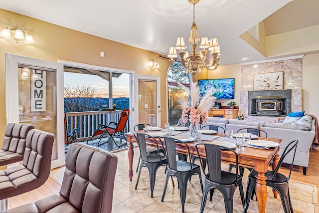 dining area with a chandelier and a tile fireplace