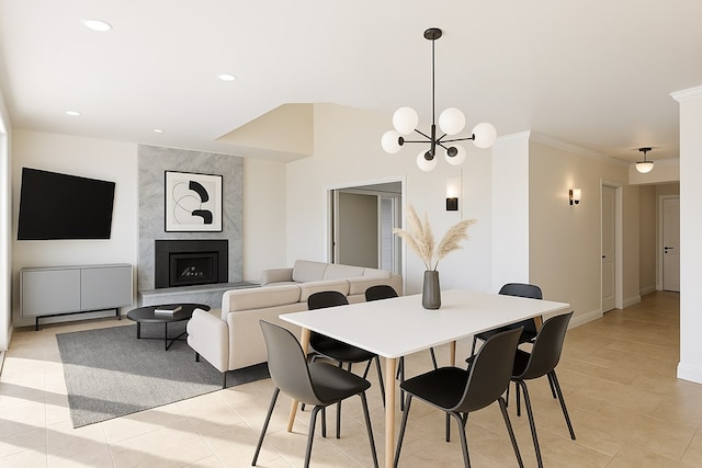dining area with a chandelier, ornamental molding, recessed lighting, light tile patterned flooring, and a premium fireplace