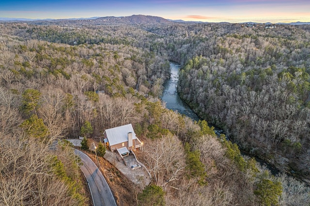 aerial view of property and surrounding area with a heavily wooded area and a mountainous background
