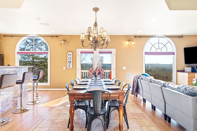 dining area with a chandelier, recessed lighting, baseboards, and light wood-style floors