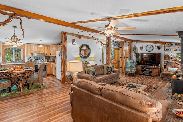 living room featuring lofted ceiling with beams, light wood-style floors, a ceiling fan, and a textured ceiling