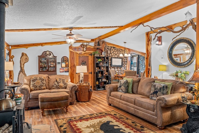 living room with a wood stove, vaulted ceiling with beams, a textured ceiling, and wood finished floors