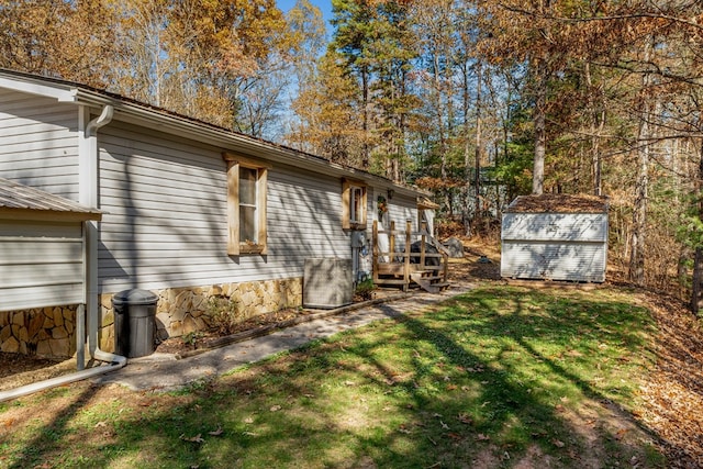 view of side of property featuring a yard, a shed, and an outbuilding