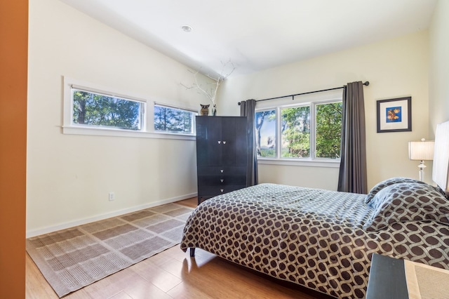 bedroom with wood-type flooring and lofted ceiling