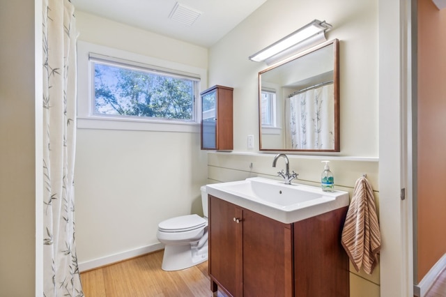 bathroom featuring wood-type flooring, vanity, and toilet