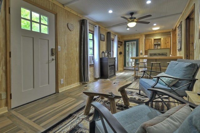 entryway featuring recessed lighting, plenty of natural light, light wood-type flooring, and wooden walls